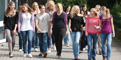 Hier wird ein Gruppenbild von Studierenden auf dem Campus gezeigt.