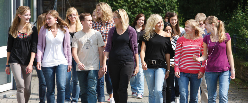 Hier wird ein Gruppenbild von Studierenden auf dem Campus gezeigt.