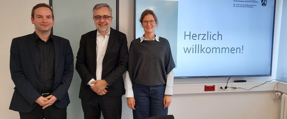 Auf dem Bild werden die Vertreterin Frau Sandra Schmidt und der Vertreter Björn Benkhoff vom Bund Deutscher Rechtspfleger Nordrhein-Westfalen e.V. mit dem Direktor der Fachhochschule NRW, Herrn Dr. Meyer, gezeigt.