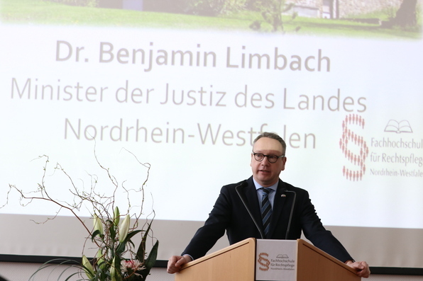 Zu sehen ist der Minister der Justiz des Landes Nordrhein-Westfalen Dr. Benjamin Limbach bei seinem Grußwort
